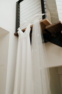 Beautiful wedding gown hanging from timber staircase with steel balustrading in McLaren Vale Weddings at Vale 194