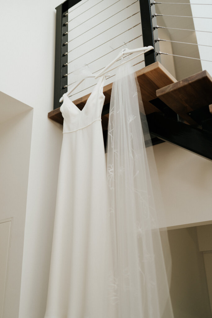 Beautiful wedding gown hanging from timber staircase with steel balustrading in McLaren Vale Weddings at Vale 194