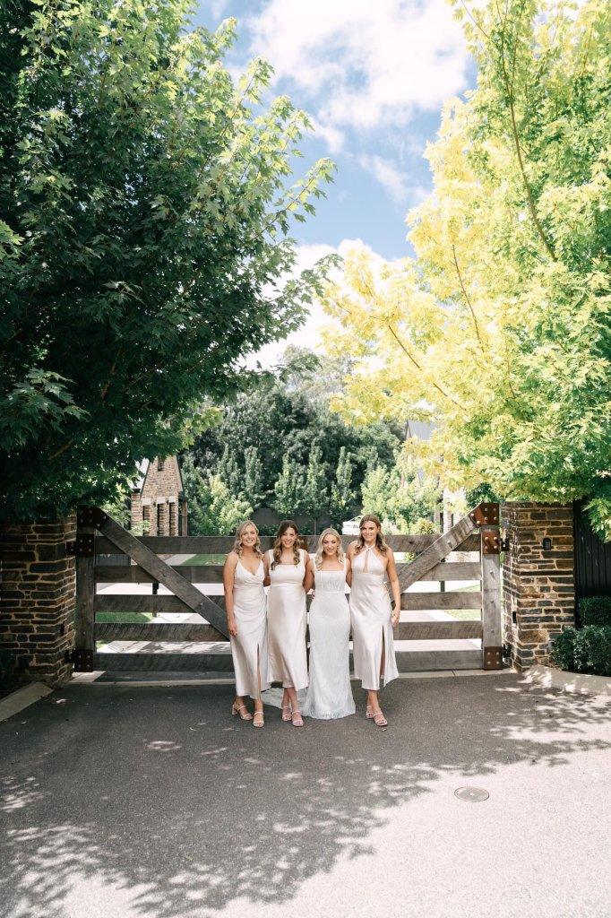 Vale 194 entrance wedding photo with a beautiful bride and her bridesmaids and beautiful trees and a timber rustic gate McLaren Vale Luxury Accommodation