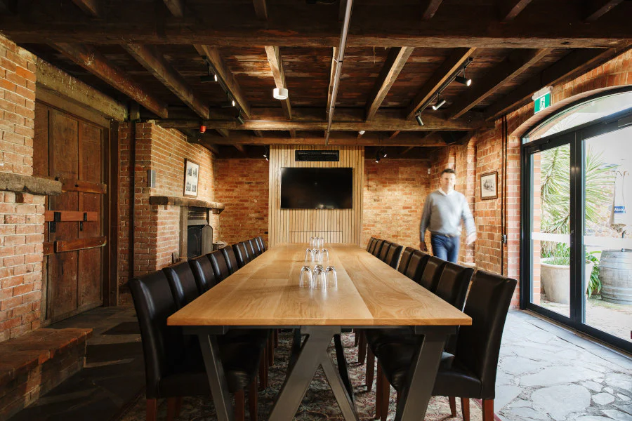 RS Wigley Room at Wirra Wirra Vineyards beautiful room with red brick walls and slate floor large board room table with presentation screen and man walking through