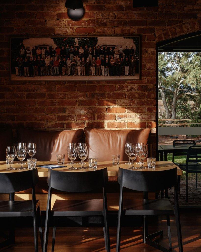 Harry's Deli Wirra Wirra set dining table with recycled red brick wall and beautiful gum trees outside the window