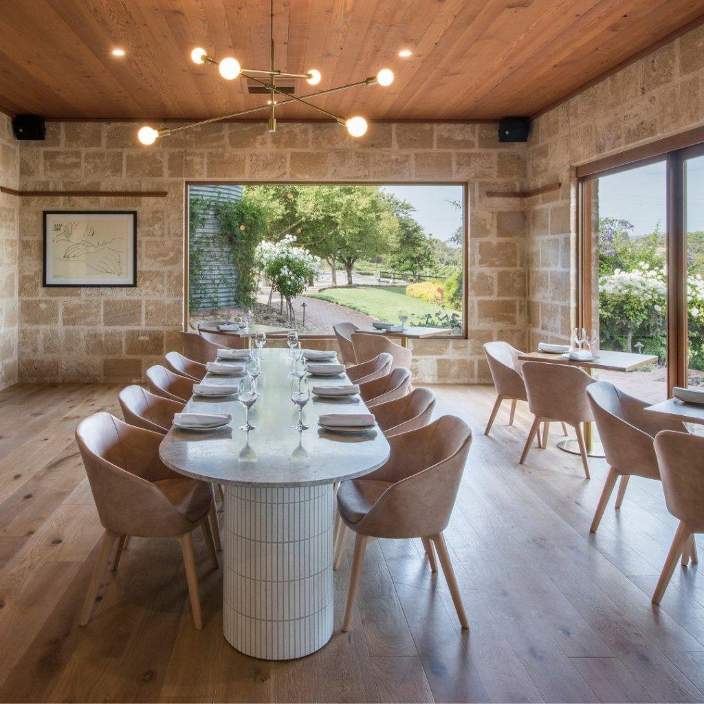 Maxwells restaurant Beautiful restaurant with classic dinner setting with designer pendant light over table, stone walls and timber floors with gargen in the background