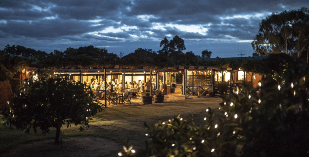 The Currant Shed reastaurant verandah at night with pretty lights in the trees and diners in the lights under the verendah