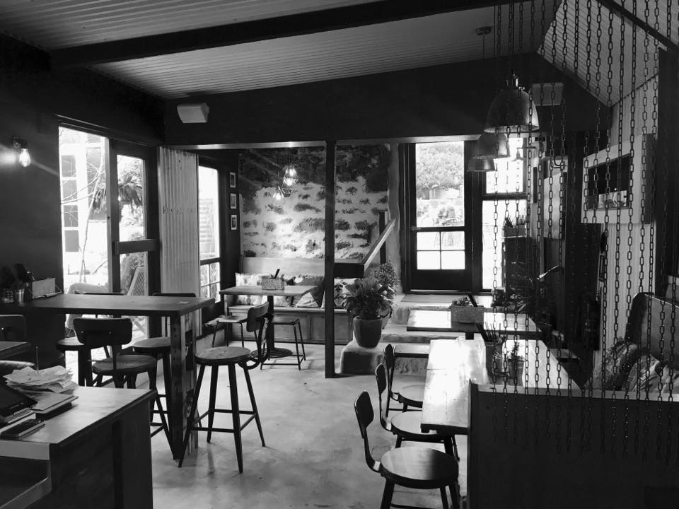 The Little Rickshaw rustic dining area with low and high seats and a few steps down from the entrance door