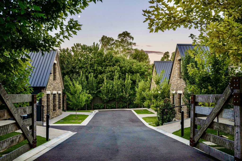 Vale 194 Entrance with rustic wooden gates and 3 stone 2 story houses visible