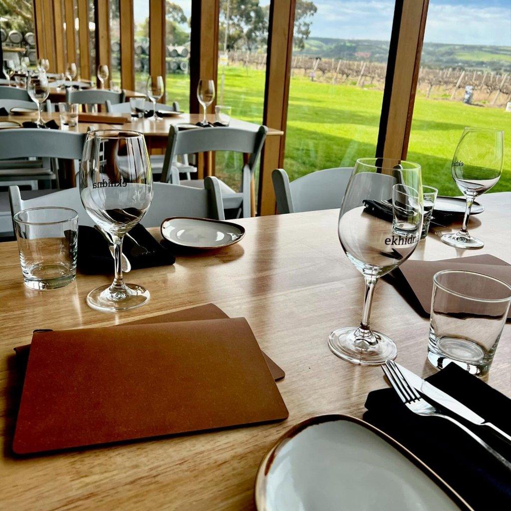 Ekhidna Kitchen and Wines dining tables set with plates cutlery and glasses with view to vineyard