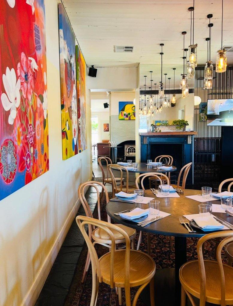 Salopian Inn with Dining tables set and with colourful art on the wall in an old historical Inn