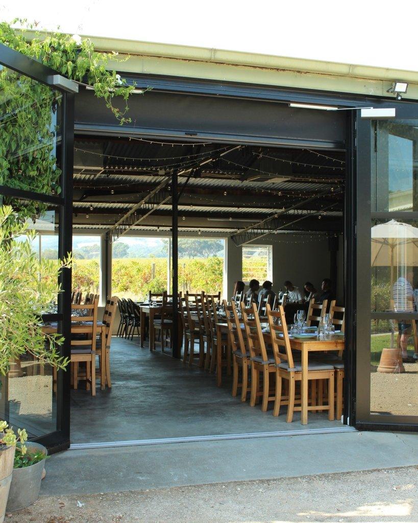 Vigna Botin Restaurant with table set and view through restaurant to vines in the background