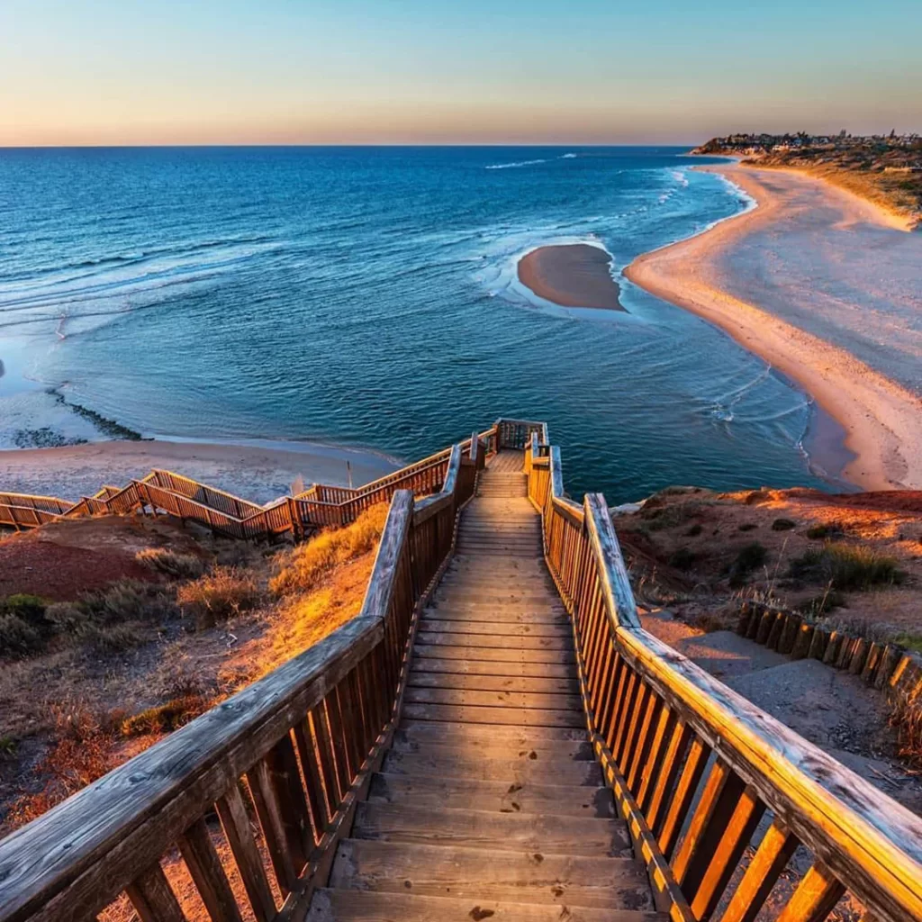 Stairs descending to beautiful Southport beach in South Australia at sunset. Beautiful golden sunset with waves.