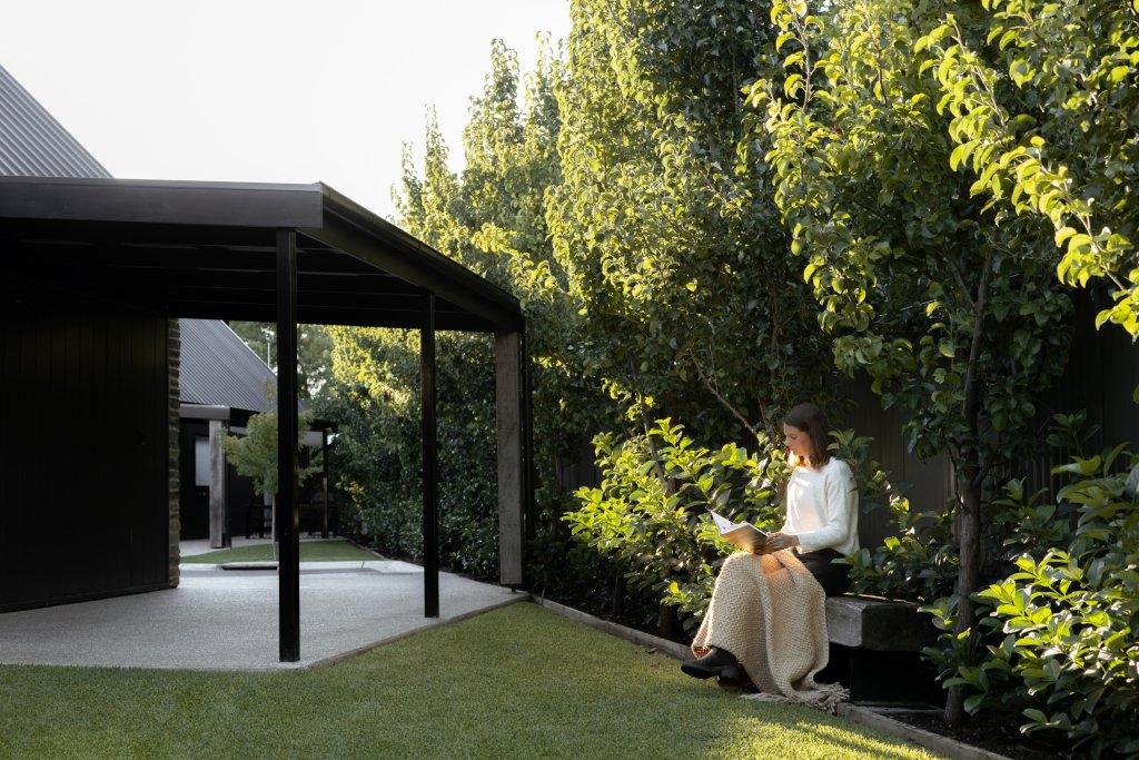 A woman sitting in a garden with a warm blanket at Vale 194 in the heart of McLaren Vale