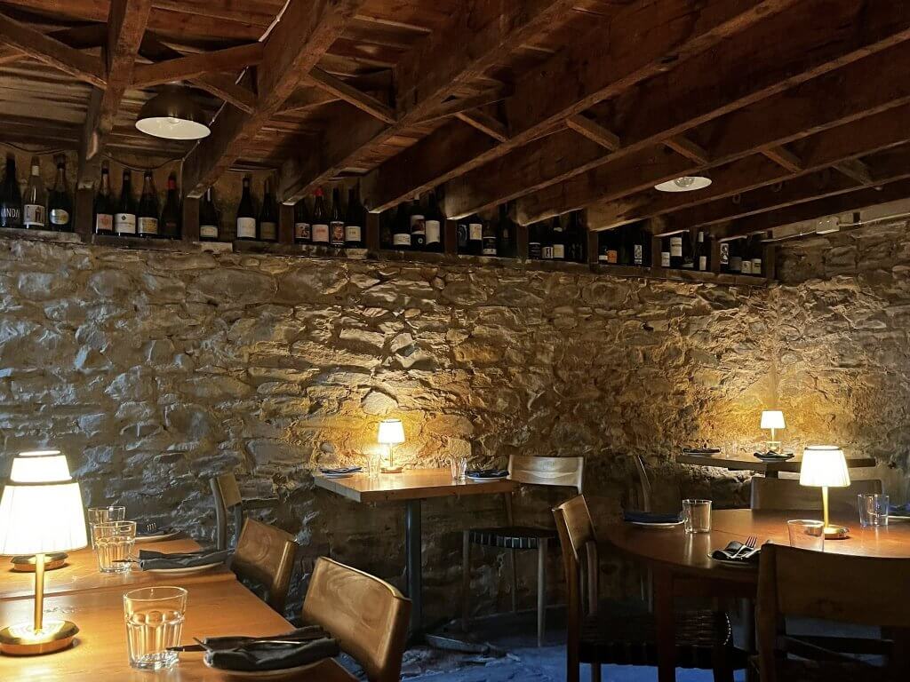 Tread Lightly Willunga Rustic stone walls with beautiful soft lighting and tables set for dinner.